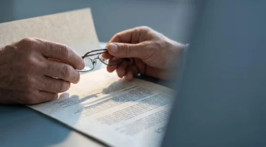Personne vulnérable face à un document contractuel complexe symbolisant les clauses restrictives d'assurance